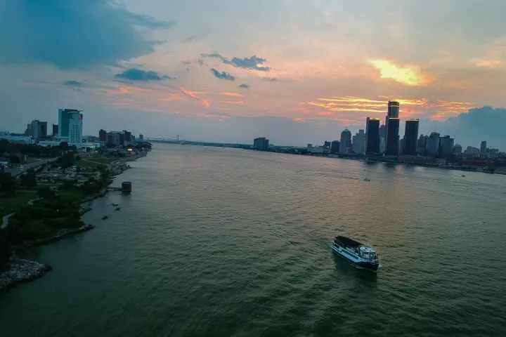 a small boat in a body of water with a city in the background