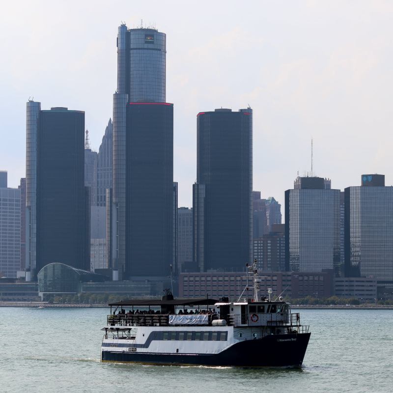 a large ship in a body of water with the view of a city in the background