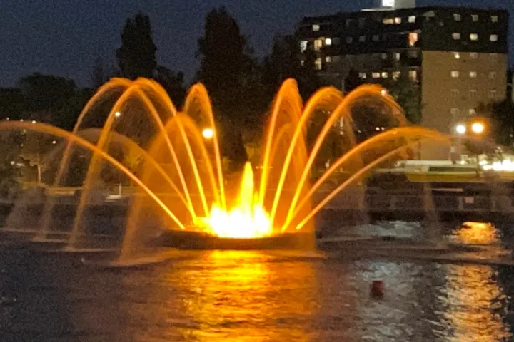 a fountain in front of a body of water