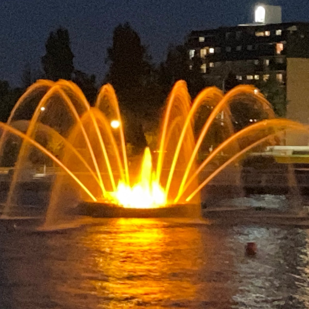 a fountain in front of a body of water