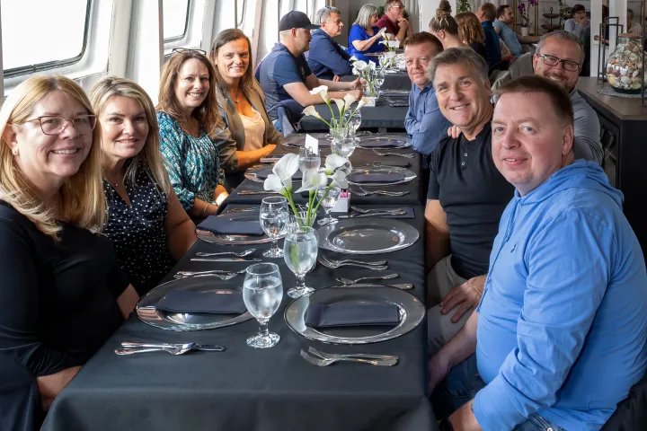 a group of people sitting at a table with wine glasses