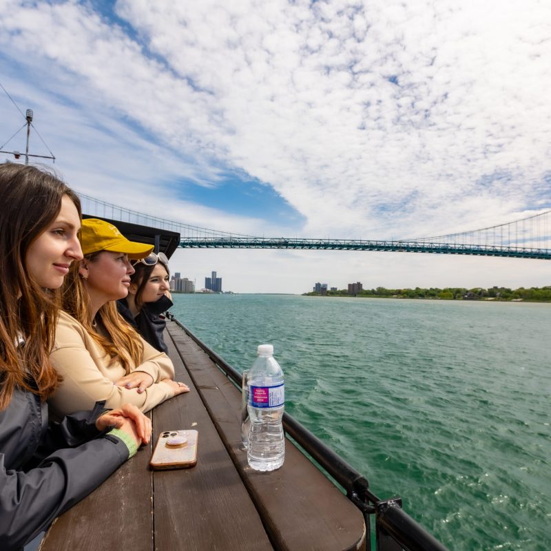 a woman sitting next to a body of water