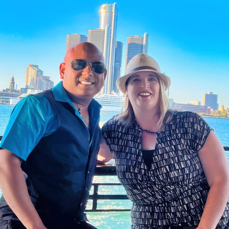 a man and a woman standing next to a body of water