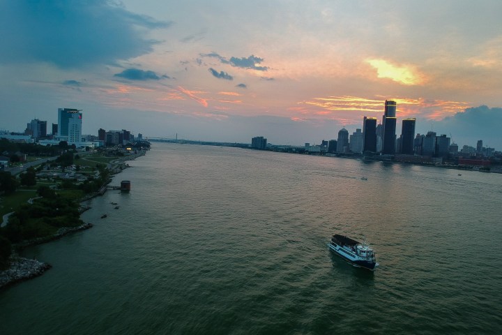 River view with city skyline at sunset, boat in the foreground.